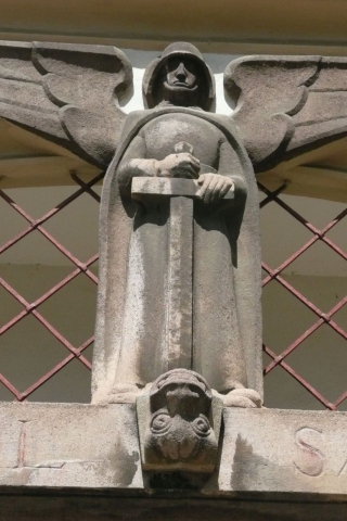 Erzengel Michael als Soldat: Kriegerdenkmal des Bildhauers Hans Mauracher (1885–1957) über dem Portal der Pfarrkirche Fohnsdorf (Steiermark). »All die Tausende, die den Tod für ihr Vaterland starben, erlebten in dieser Denkmalfigur eine Verkörperung von visionärer Gewalt«, hieß es in einer Denkschrift anlässlich der Einweihung von 1930. (Foto: Werner Suppanz, August 2011) Der heilige Michael gilt unter anderem als Schutzpatron der Soldaten und Krieger; so wird er in der christlichen Ikonographie häufig mit Rüstung, Schwert und Schild dargestellt (zum Beispiel auch am 1913 eingeweihten Völkerschlachtdenkmal in Leipzig).