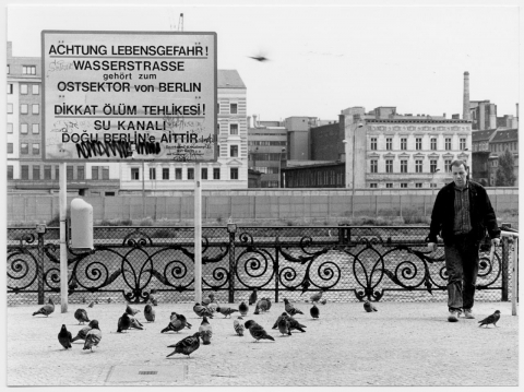 Am äußersten Rand West-Berlins. Das zweisprachige Schild an der Spree zwischen Kreuzberg (West) und Friedrichshain (Ost) ist auch ein Dokument für die im östlichen Kreuzberg konzentrierte Migrationsgesellschaft. Kurz nach Entstehung dieses Fotos dürfte das Schild abmontiert worden sein. (Deutsches Historisches Museum, Foto: Birgit Schirmeier, 1990)