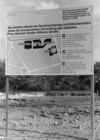 Informationstafel am ehemaligen Gelände von Gestapo, SS und Sicherheitsdienst (SD), 1986. Das Areal wirkt hier wie eine Mondlandschaft; die sachlich-bürokratische Tafel bildet dazu einen markanten Kontrast. (Foto: Jürgen Henschel; FHXB Friedrichshain-Kreuzberg Museum)