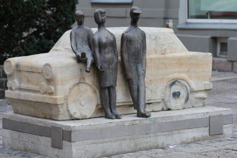 Steinerne Erinnerung: Trabi-Denkmal von 1998 auf dem Georgenplatz in Zwickau (Foto von 2011). Wegen häufiger Beschmierungen wurde das Monument 2014/15 an einen anderen Standort versetzt. (Wikimedia Commons, Astro111, Zwickau Georgenplatz Trabantdenkmal, CC BY-SA 3.0)