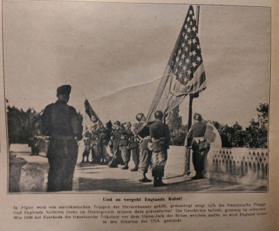 Das im Brandt-Bericht von 1946 erwähnte retuschierte AP-Foto für die deutsche Presse. Es zeigt eine Flaggenparade der Alliierten nach der Landung in Algier/Nordafrika im November 1942. Auf Befehl von Dr. Paul Karl Schmidt war die Flagge Großbritanniens entfernt worden, sodass der Eindruck entstand, die alliierten Truppen kämpften nur für die Errichtung des US-Imperiums und England werde »in den Schatten der USA gedrückt« (Bildlegende). (aus: Berliner Illustrierte, 24.12.1942) Das im Brandt-Bericht von 1946 erwähnte retuschierte AP-Foto für die deutsche Presse.