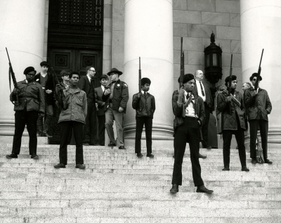 Mitglieder der Black Panther Party (BPP) aus Seattle auf den Stufen des Kapitols in Washington, 28. Februar 1969. Sie protestierten gegen ein Gesetz, das solche bedrohlich wirkenden öffentlichen Auftritte mit Schusswaffen gerade unter Strafe stellen sollte.(State Governors’ Negative Collection, 1949–1975, Washington State Archives, Digital Archives) Mitglieder der Black Panther Party (BPP) aus Seattle