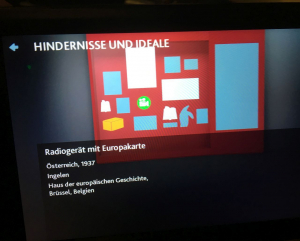 Die in einer Ausstellungsvitrine angeordneten Objekte werden schemenhaft auf dem Display des Tablets angezeigt. Erst nach Berührung des entsprechenden Symbols werden knappe »Metadaten« zum Ausstellungsobjekt sichtbar – wie hier zu einem Radioempfänger aus dem Jahre 1937. In Vitrinen mit vielen und oftmals kleinen Objekten wird die Ortung und Identifizierung ein wahrer Spießrutenlauf. (Foto: Andreas Fickers)