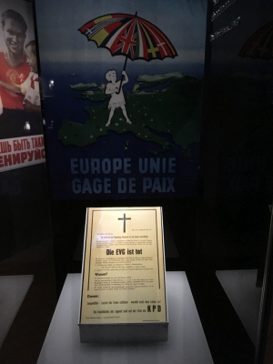 Beispiel einer gelungenen Inszenierung von Objekten im Haus der europäischen Geschichte: pro-europäisches Plakat als Hintergrundbild für eine »Todesanzeige« der Europäischen Verteidigungsgemeinschaft aus der Feder der Kommunistischen Partei Deutschlands vom 6. September 1953. (Foto: Andreas Fickers)