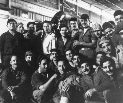 Das Eisenwalzwerk Israeli Steel Mills Ltd. in Akko 1962: Der Aufbau des Werks wurde aus Mitteln des Wiedergutmachungsabkommens finanziert. Ein erheblicher Teil solcher Zahlungen wurde in Form von Maschinen, technischem Zubehör und Dienstleistungen von Deutschen in Israel erbracht – was vielfach mit Konflikten verbunden war. Hier scheinen sich der deutsche Ingenieur und die israelischen Arbeiter aber gut verstanden zu haben. (picture-alliance/ullstein bild/Claude Jacoby)