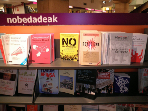 Auslage einer bekannten baskischen Buchhandlung mit Titeln zur Protestbewegung des Frühsommers 2011 (Wikimedia Commons, Joxemai, M15 liburuak, CC BY-SA 3.0)