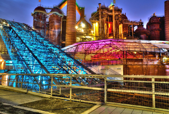 Weltkulturerbe Völklinger Hütte mit Lichtinstallation. Das Eisenwerk wurde 1986 geschlossen und 1994 in die UNESCO-Liste aufgenommen. (Wikimedia Commons, Jotha56, Hütte Völklingen, am Abend mit Beleuchtung, CC BY-SA 3.0; Foto von 2012) Weltkulturerbe Völklinger Hütte mit Lichtinstallation. Das Eisenwerk wurde 1986 geschlossen und 1994 in die UNESCO-Liste aufgenommen. (Wikimedia Commons, Jotha56, Hütte Völklingen, am Abend mit Beleuchtung, CC BY-SA 3.0; Foto von 2012)