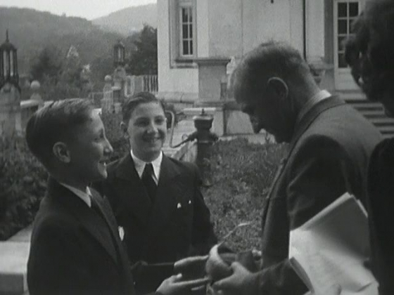 Micha und Sascha Illich bei der Schlüsselübergabe. Filmstill aus: »Reporter 1941–1942«, 1942, Regie: Ellen »Maexie« Illich, Steven Spielberg Film and Video Archive (Ellen Rose Regenstreif Film Collection), United States Holocaust Memorial Museum (USHMM). Copyright: Yvonne Illich.