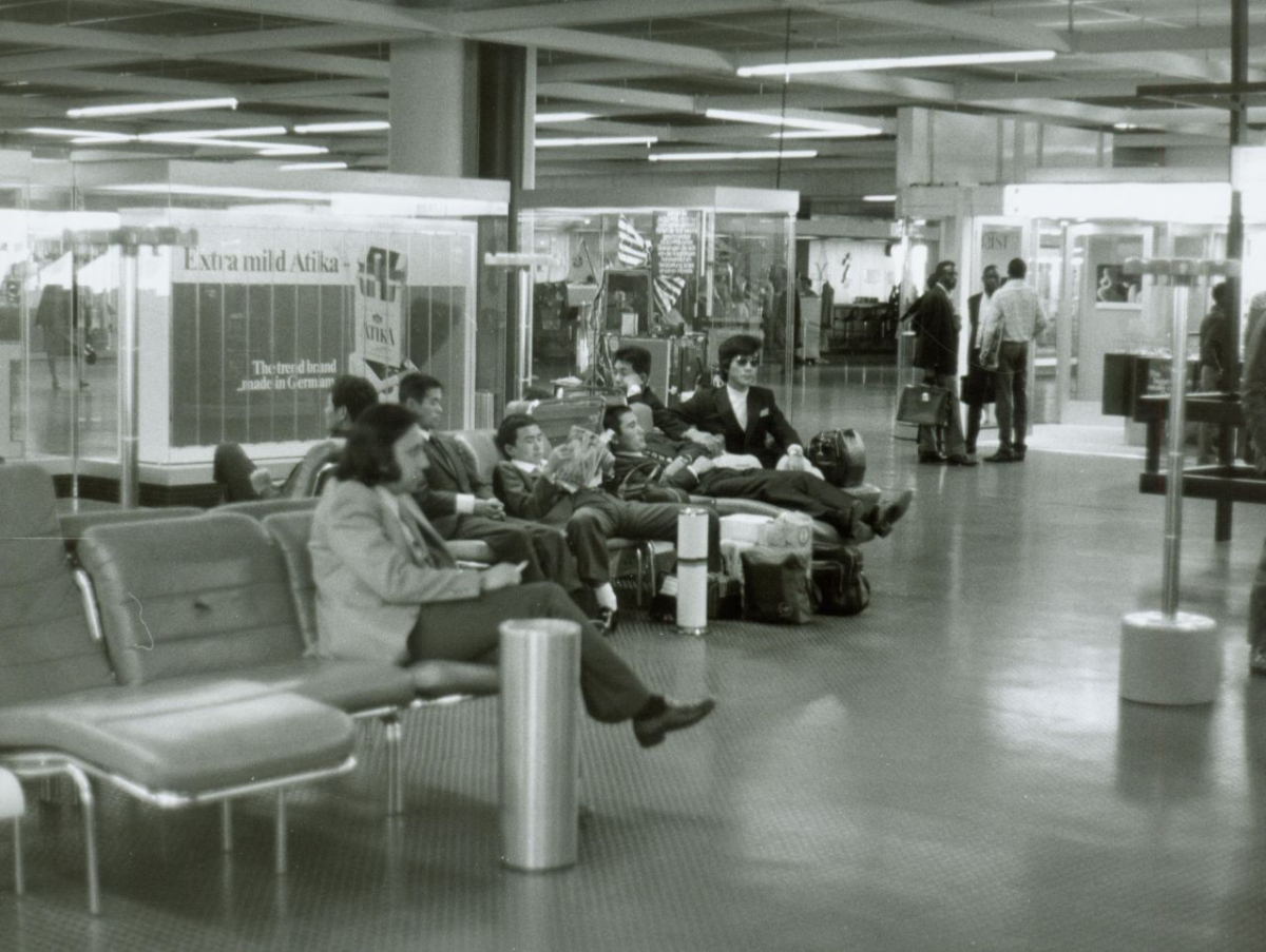 Internationales Reisepublikum im Transitbereich B des Terminals 1 in Frankfurt a.M., 1970er-Jahre. In diesem Bereich warteten zwischen 1980 und 1988 über 40.000 Asylbewerber:innen auf die Einreise-Erlaubnis. (Milan Skaryd, Fraport AG, Fraport Archiv) Internationales Reisepublikum im Transitbereich B des Terminals 1 in Frankfurt a.M., 1970er-Jahre. In diesem Bereich warteten zwischen 1980 und 1988 über 40.000 Asylbewerber:innen auf die Einreise-Erlaubnis. (Milan Skaryd, Fraport AG, Fraport Archiv)