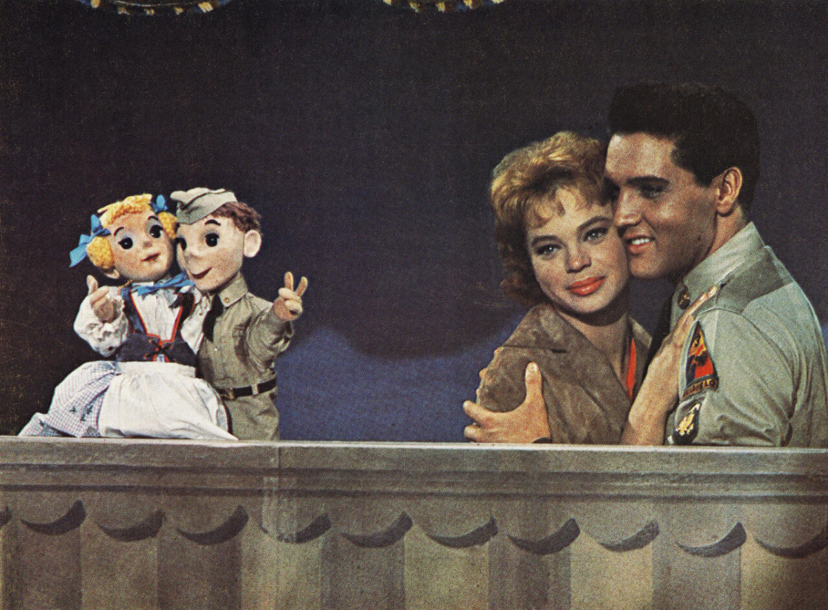 Elvis mit Kasperle: Werbefoto für den Film »G.I. Blues«/»Cafe Europa« (USA 1960, Regie: Norman Taurog, Hauptrollen: Juliet Prowse, Elvis Presley) (picture-alliance/United Archives/IFTN)