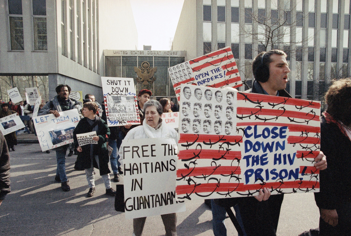 Eine weitere Variante der US-Flagge: Demonstration einer ACT UP-Gruppe gemeinsam mit Haitianer:innen in New York, 8. März 1993. Der Protest richtete sich gegen die Inhaftierung von Aids-infizierten haitianischen Flüchtlingen in Guantanamo und hatte somit eine doppelte demokratiepolitische Stoßrichtung. (picture-alliance/Associated Press/Andrew Savulich)