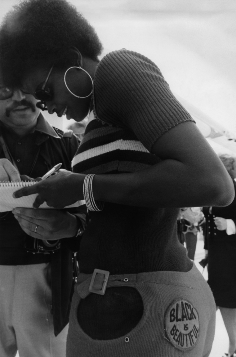 A young African American woman with a sticker declaring ›BLACK IS BEAUTIFUL‹ on her clothing, 1960s (dpa/Süddeutsche Zeitung Photo)