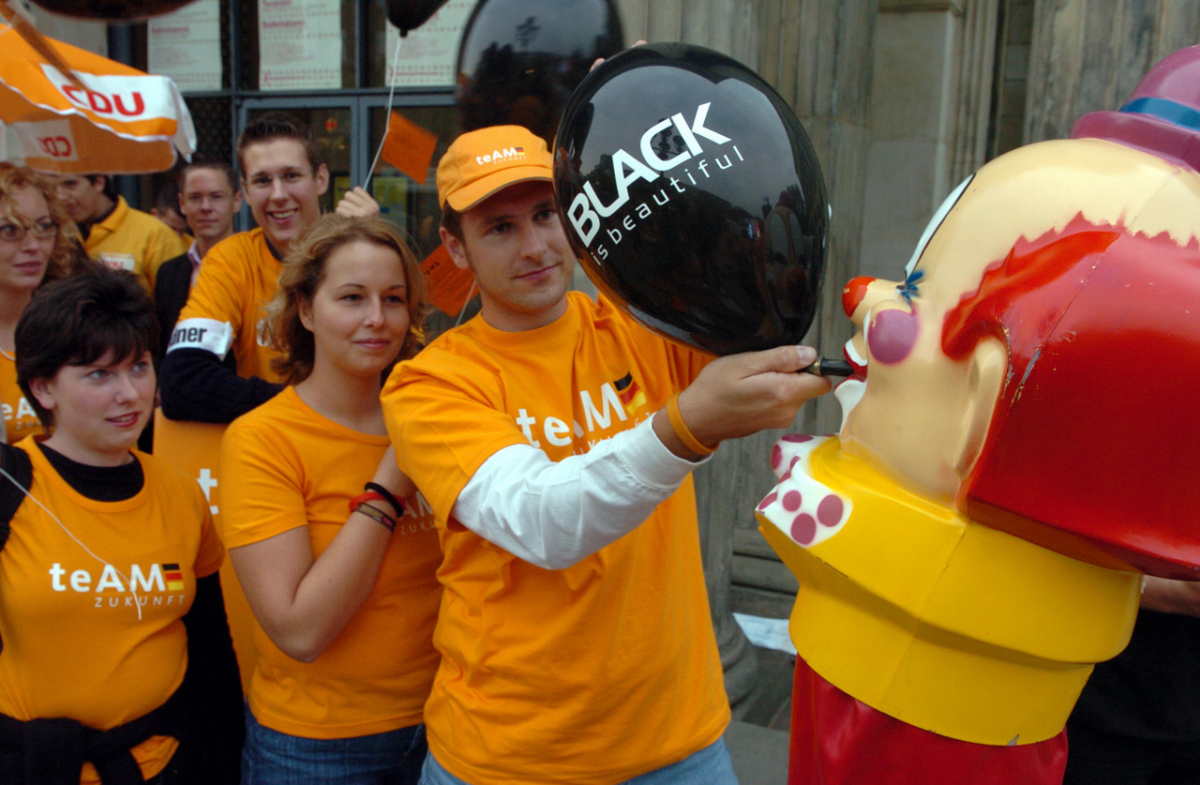 Hanover, August 2005: Members of the Junge Union fill black balloons for an election campaign event with CDU chairwoman Angela Merkel who was then running for chancellor. The slogan ›Black is beautiful‹ had an astonishing longevity. (picture-alliance/dpa/dpaweb/Wolfgang Weihs)