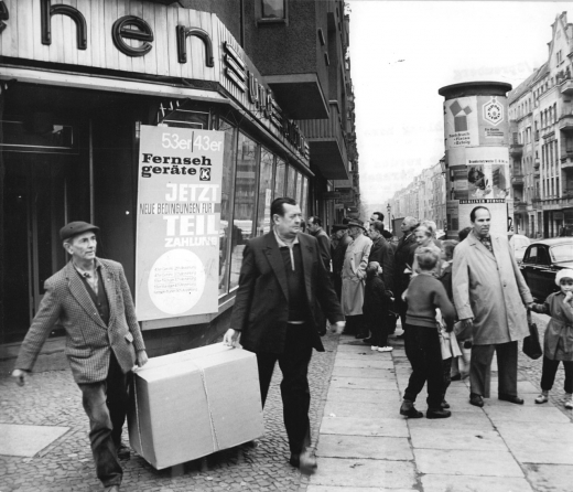 Citizens of the German Democratic Republic purchasing a television set in 1964 thanks to installment credits. Partial payments were only one of many factors that determined who had access to consumer markets and under what conditions. Several characteristics of the market for television sets in the GDR could be found in many other societies as well, like the problem of financing for individual households or overcoming consumer mistrust. But the problems were not necessarily solved in the same ways or by the same institutions. Other market practices, like pricing and competition, worked in idiosyncratic ways and could change over time. New economic sociology makes it possible to look for the ways in which markets are embedded in historical societies, thus questioning the economic ideal of an ahistorical and efficient market mechanism. This is crucial for understanding marketization as a historical process with a complex background and undetermined effects. (Bundesarchiv/Federal Archives, Picture 183-O1014-0016-001, Allgemeiner Deutscher Nachrichtendienst – Zentralbild, Photo: Joachim Spremberg)