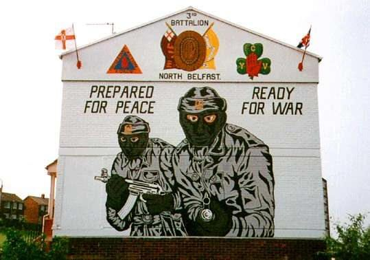 Noch heute erinnern die Murals in Belfast an den Nordirland-Konflikt. Dieses Wandgemälde mit den Paramilitärs der Ulster Volunteer Force wurde 2004 aufgenommen.(Wikimedia Commons, Lasse1974, Glenbryne, CC0 1.0) Noch heute erinnern die Murals in Belfast an den Nordirland-Konflikt. Dieses Wandgemälde mit den Paramilitärs der Ulster Volunteer Force wurde 2004 aufgenommen. (Wikimedia Commons, Lasse1974, Glenbryne, CC0 1.0)