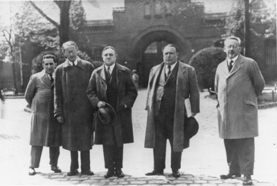 Carl von Ossietzky (Mitte) mit seinen Anwälten Kurt Grossmann, Rudolf Olden, Alfred Apfel und Kurt Rosenfeld (v.l.n.r.) vor dem Haftantritt im Strafgefängnis Tegel, 10. Mai 1932. Im Weltbühnen-Prozess war Ossietzky am 23. November 1931 wegen des angeblichen Verrats militärischer Geheimnisse zu 18 Monaten Haft verurteilt worden. Durch eine Weihnachtsamnestie kam er im Dezember 1932 vorzeitig frei, wurde nach der nationalsozialistischen Machtübernahme jedoch bereits am 28. Februar 1933 wieder verhaftet. (Bundesarchiv, Bild 183-B0527-0001-861, Allgemeiner Deutscher Nachrichtendienst – Zentralbild, Fotograf/in unbekannt)